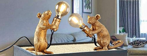 A pair of gold mice figurines holding light bulbs