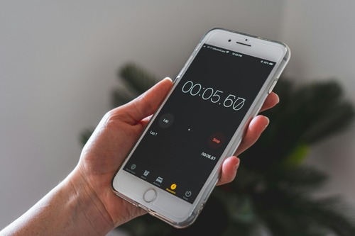 A person displaying a phone with a visible timer