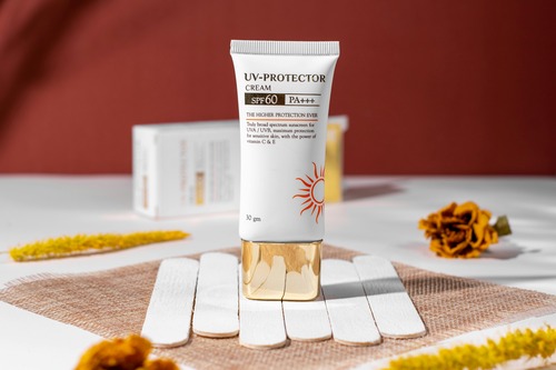 A sun protection cream placed on a table adorned with flowers.